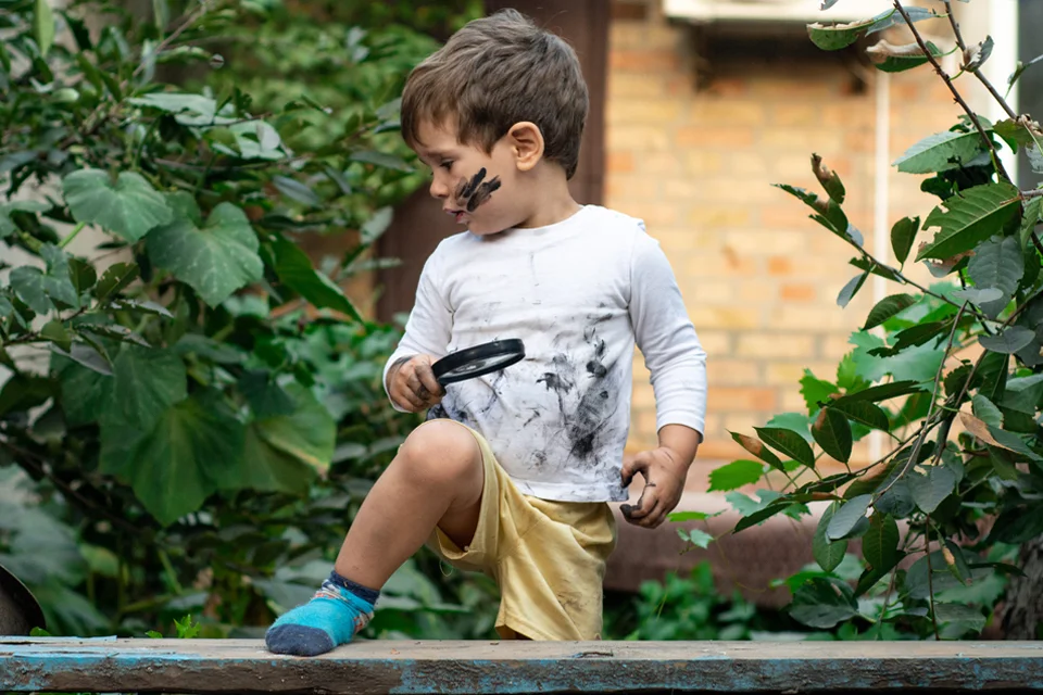 Un enfant avec un vêtement blanc totalement tâché