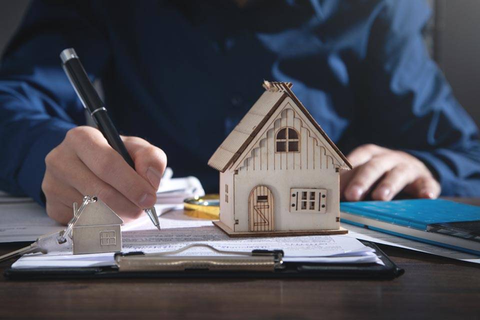 Une personne signe un contrat d'assurance pour son logement