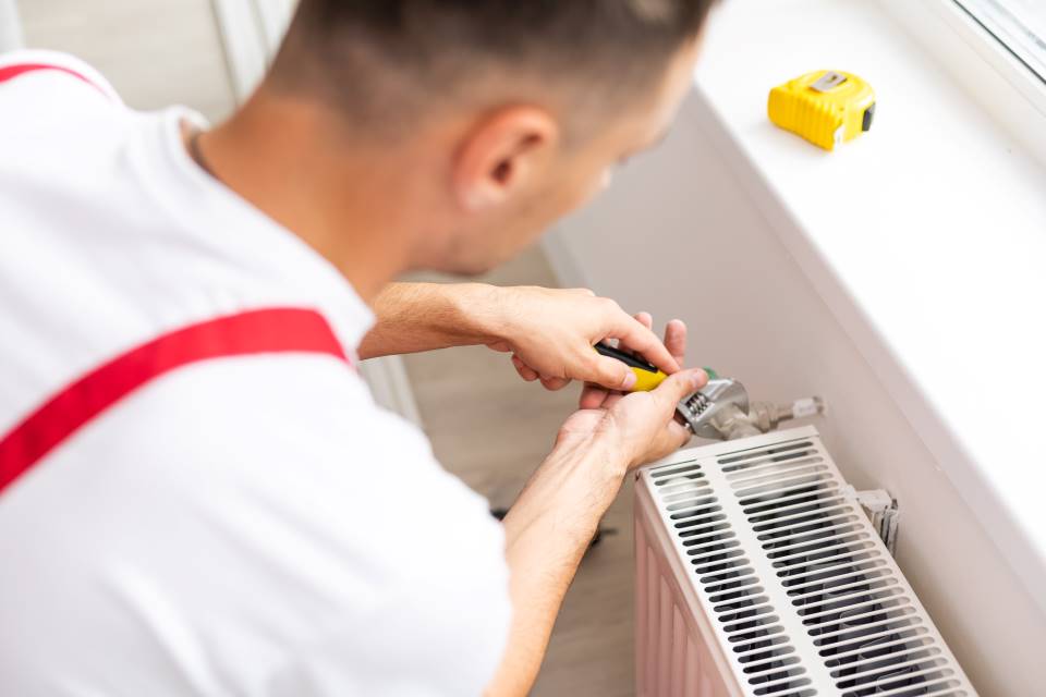 Homme qui répare un chauffage