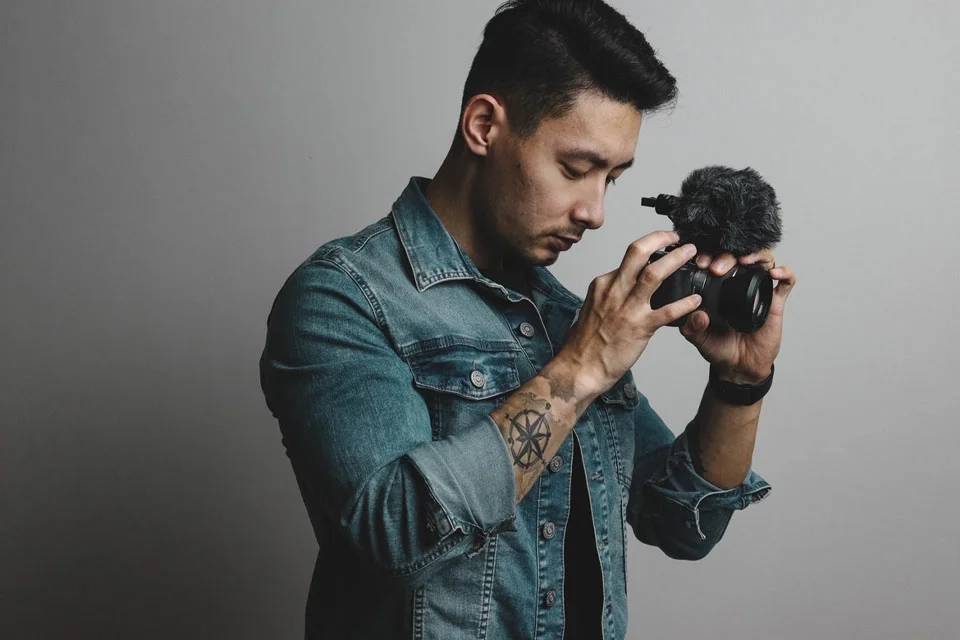 Les outils gratuits pour créer une vidéo de visite virtuelle Homme tenant une caméra et faisant l'action de filmer